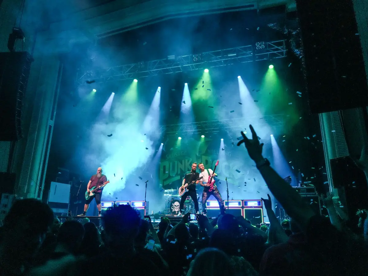 Punk Rock Factory on stage under green and blue lights, confetti falling over a packed crowd